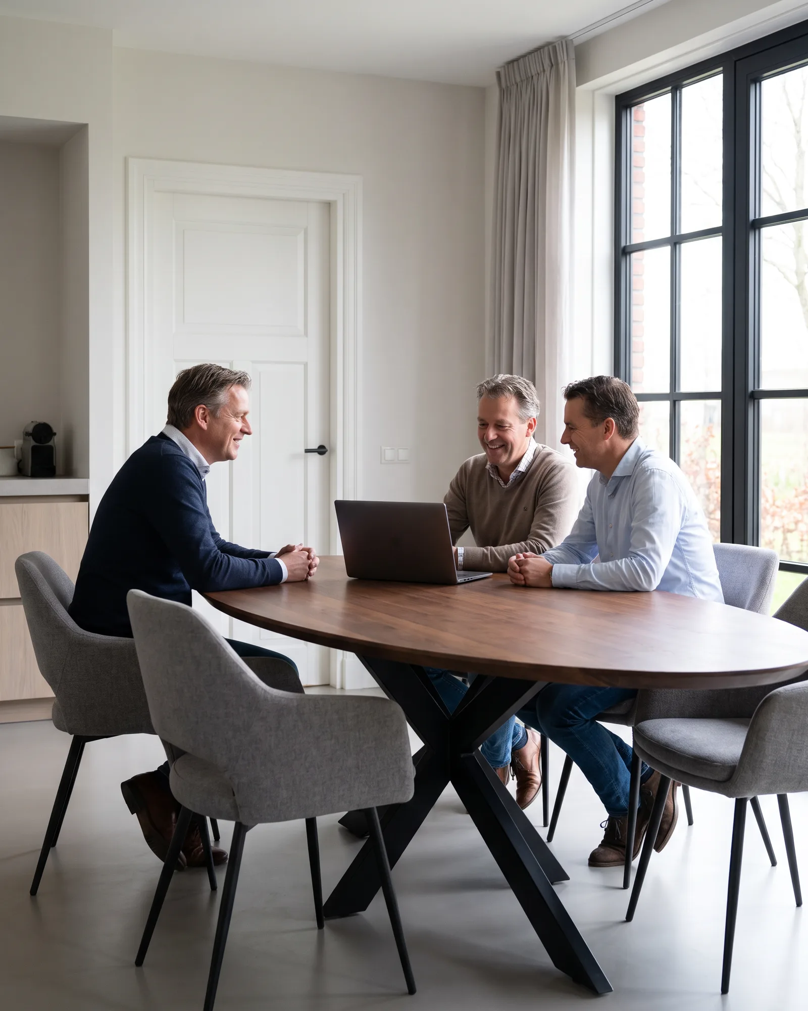 Een stel loopt met een adviseur van ons de begroting door aan een ovale tafel