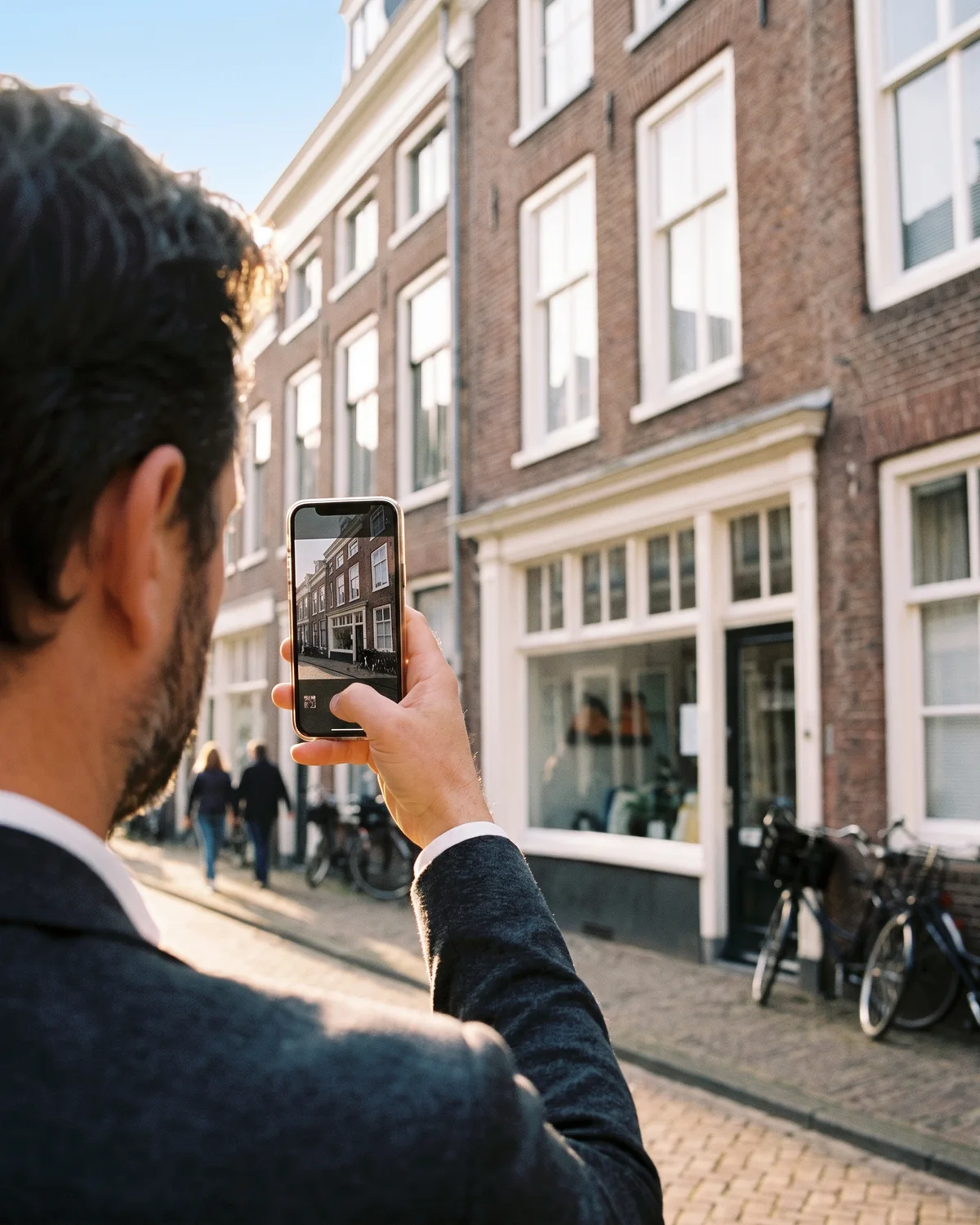 Een belegger maakt foto's van de gevel van een pand dat hij wil kopen